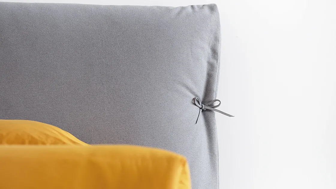 Eden Advance padded bed with flakes on the headboard in Noctis fabric.