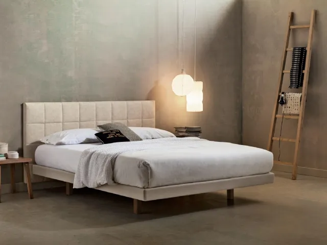Double bed in eco-nubuck. Suspended headboard with headrest applied to the wall by Veneran.
