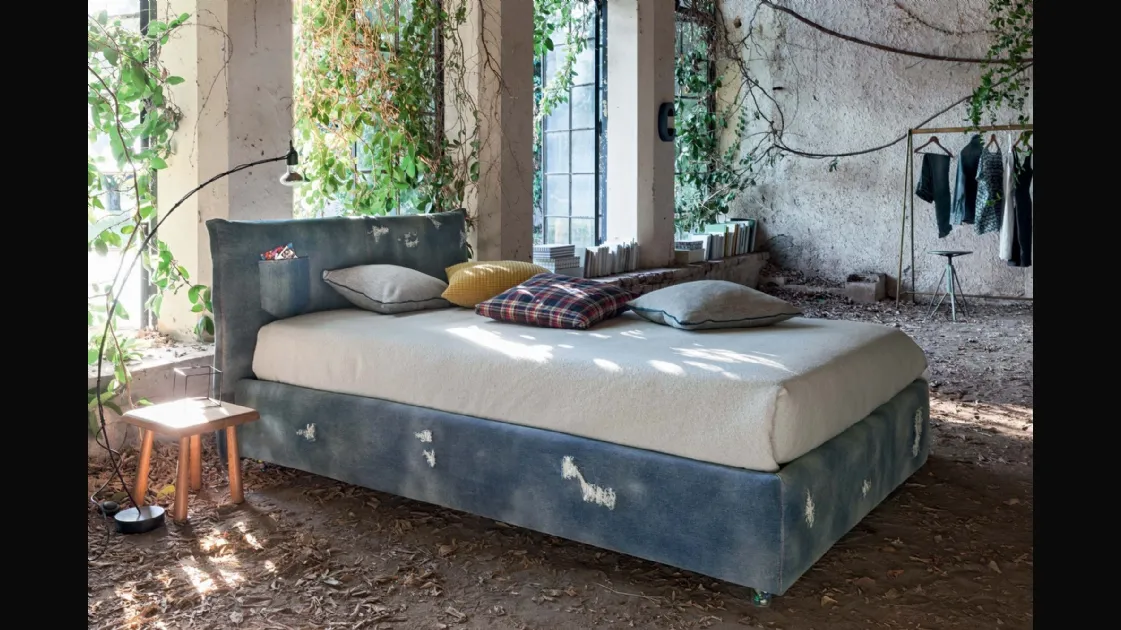 Bed with headboard covered in distressed denim with transparent feet with beads inside Veneran's Twin Line.